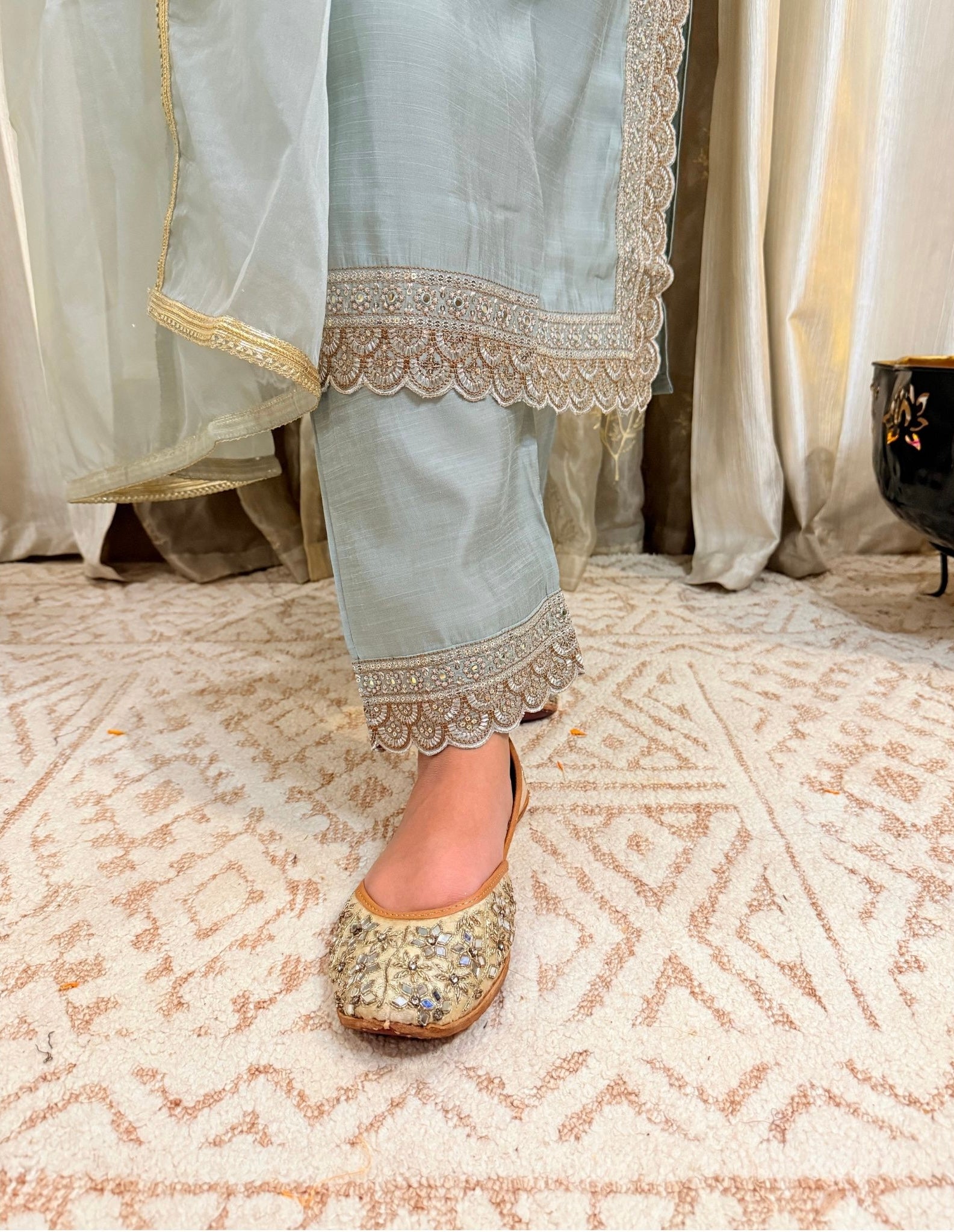 Traditional light blue outfit with embroidered details on a patterned floor.MEGHGREYISHBLUEFESTIVESUIT